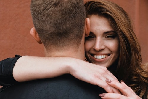 smiling woman hugging man